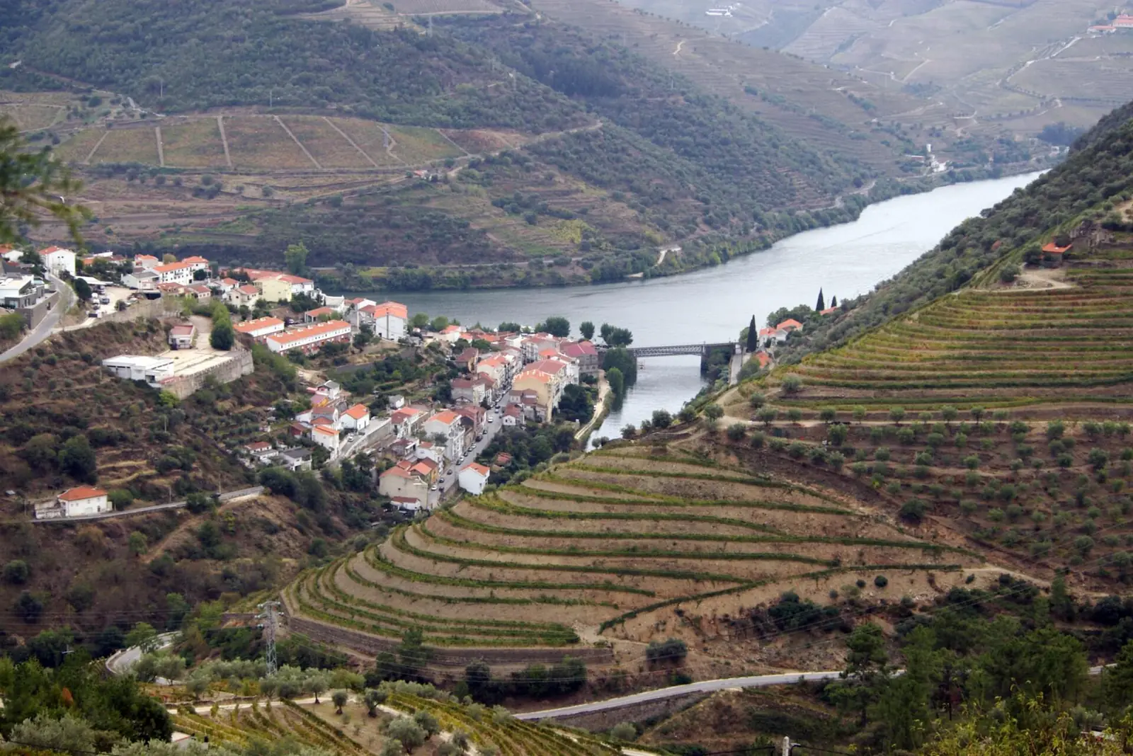 Vale do Douro, em Portugal, com vinhedos em socalcos e a vila do Pinhão à beira do rio