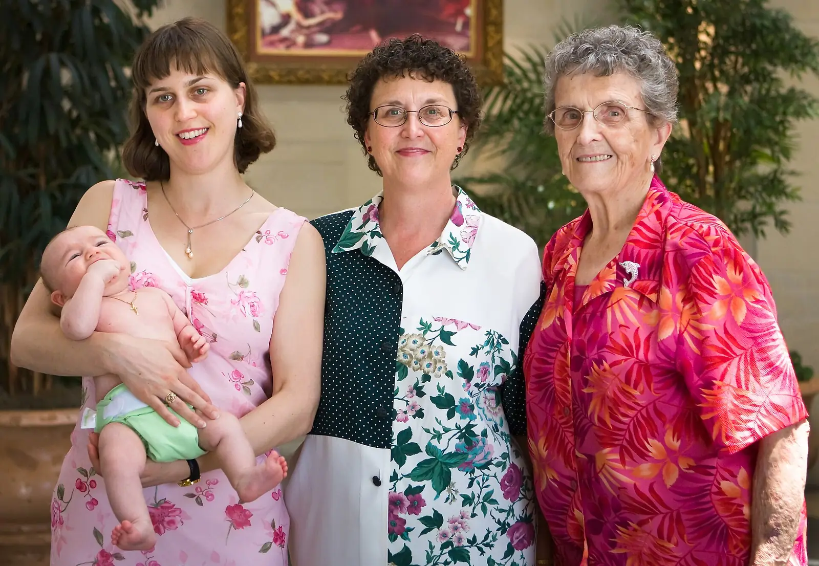Quatro gerações de uma família reunidas: bisavó, avó, mãe e um bebê no colo, sorrindo